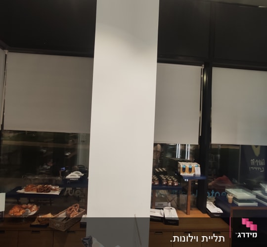 חנות עם מדפים, מאפים ומקרר תצוגה מואר